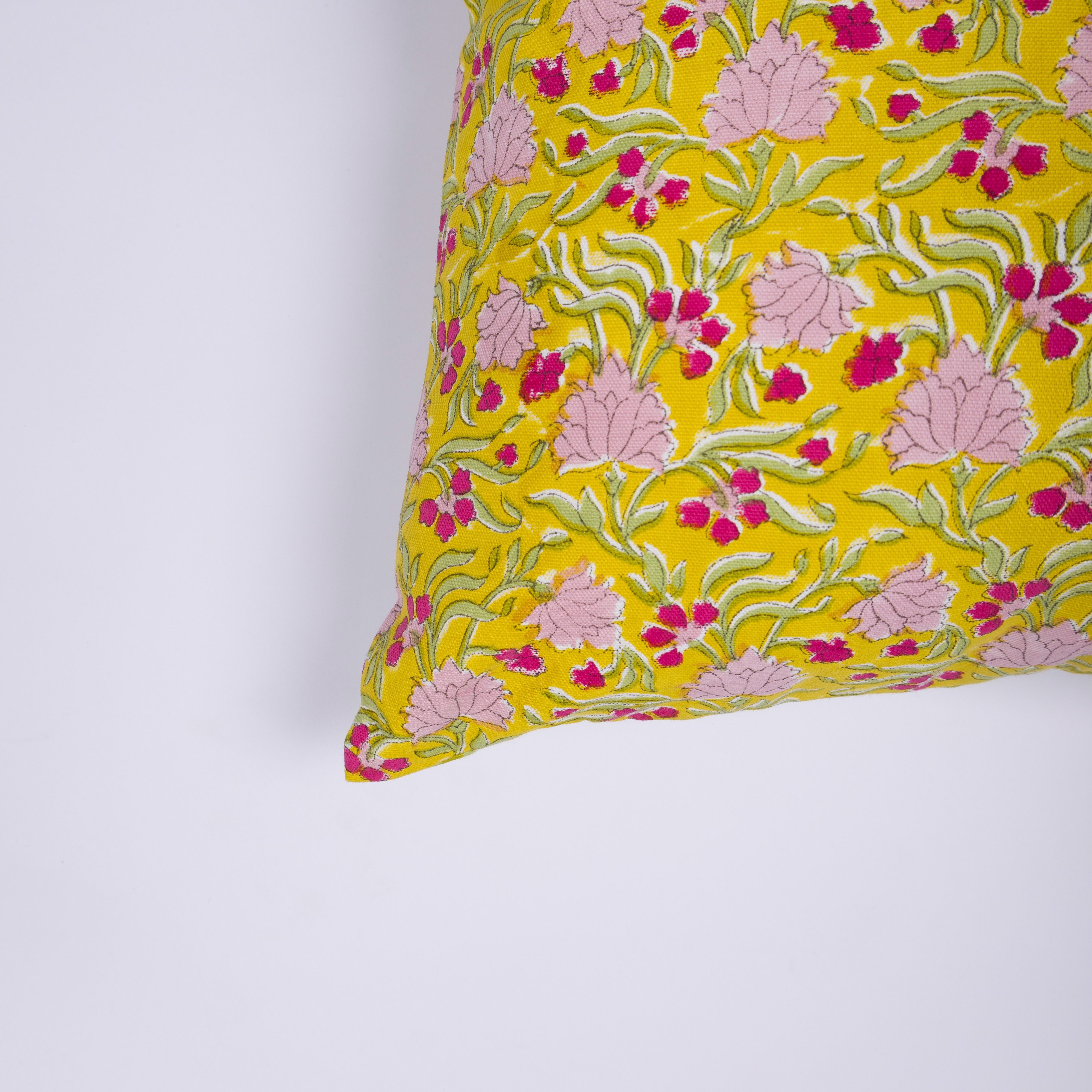 Vibrant yellow and green botanical pillow designed to bring "the spirit of spring" into modern homes.