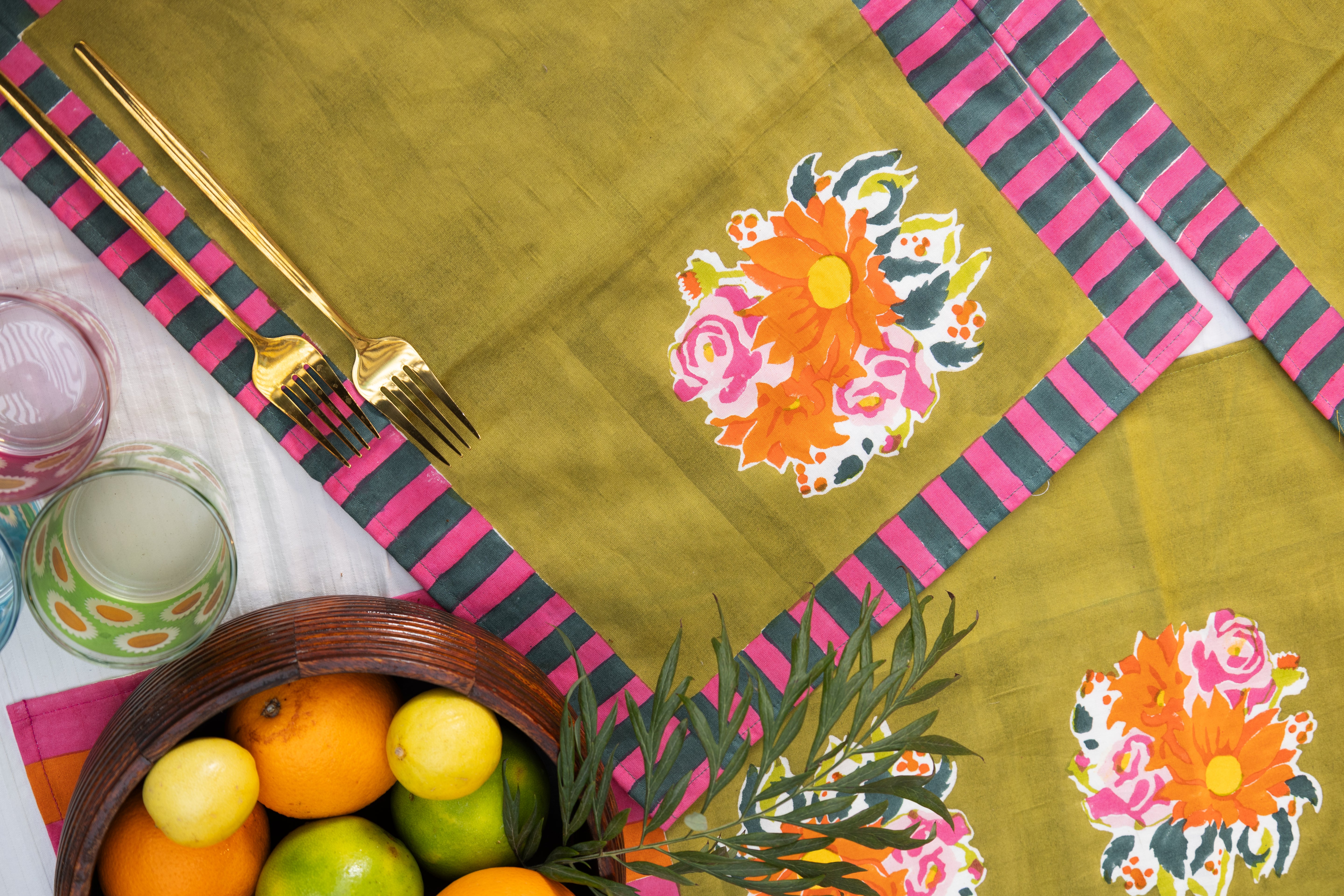 Decorative green cotton placemats with hand-printed motifs and striped geometric borders, inspired by the heritage of the Thar region.